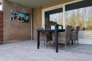 ein schwarzer Tisch und Stühle auf einer Terrasse in der Unterkunft Schorrebloem 10 in Nieuwvliet + 7 Fotos