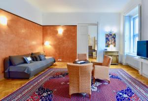 ein Wohnzimmer mit einem Sofa, Stühlen und einem Teppich in der Unterkunft Stylish, Cosy & Central "Self-Check-In" Apartment in Wien