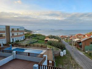 uma vista para o oceano a partir da varanda de um edifício em Apto com vista para o mar e o farol - loft 323 em Laguna