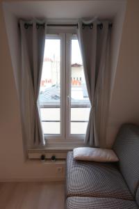 a window with curtains and a couch in a room at Paris 17 - Batignolles - Studio 10 m2 - 1 room - Single occupancy - near Champs Elysées & Montmartre & Dpt stores in Paris