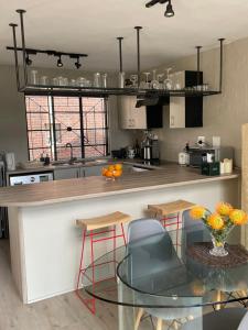 a kitchen with a counter with a glass table at Loft Apartment Cape Town The Waterkant in Cape Town