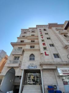 ein hohes Gebäude mit einer Treppe davor in der Unterkunft واحة طيبة للشقق الفندقية in Medina