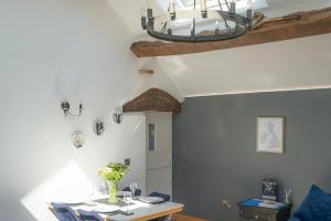 a dining room with a table and blue chairs at Naze View Barn - Cosy, with all mod cons in Whaley Bridge