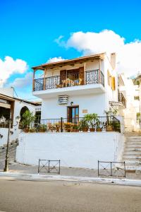 ein weißes Haus mit Balkon auf einer Straße in der Unterkunft Evelina's House in Platanias
