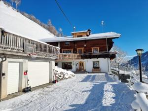 une maison dans la neige avec son garage dans l'établissement Ferienwohnungen Birkleiten, à Bramberg am Wildkogel