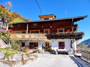 a large wooden house with flowers in front of it at Ferienwohnungen Birkleiten in Bramberg am Wildkogel