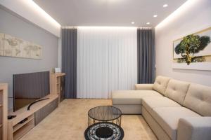 un soggiorno con divano e TV di Comfy Central 1 Bedroom Apt with Terrace and View a Heraklion