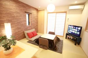 a living room with a couch and a table at 一棟貸切り宿 GuestHouse 嵯峨嵐山 in Kyoto