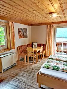 1 dormitorio con 1 cama, mesa y sillas en Ferienwohnungen Birkleiten, en Bramberg am Wildkogel