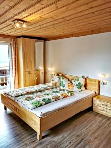 Bett in einem Schlafzimmer mit Holzdecke in der Unterkunft Ferienwohnungen Birkleiten in Bramberg am Wildkogel