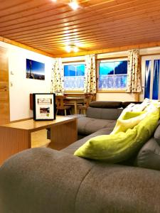 ein Wohnzimmer mit einem Sofa und einem Tisch in der Unterkunft Ferienwohnungen Birkleiten in Bramberg am Wildkogel