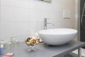 La salle de bains est pourvue d'un lavabo et d'un bol sur un comptoir. dans l'établissement Dépendance Ragaraja con sauna e idromassaggio, à Pordenone