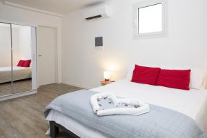 1 dormitorio con 1 cama blanca grande con almohadas rojas en Dépendance Ragaraja con sauna e idromassaggio en Pordenone