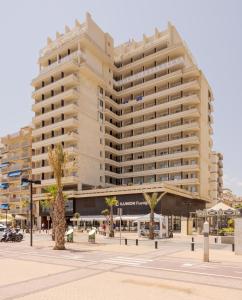 un gran edificio en una calle de la ciudad con palmeras en Ilunion Fuengirola, en Fuengirola