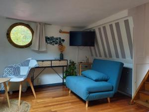 uma sala de estar com uma cadeira azul e uma secretária em Appartement atypique indépendant sur péniche em Metz