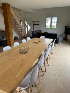 a wooden table with white chairs in a living room at Le gîte des Vosges II in Fraize