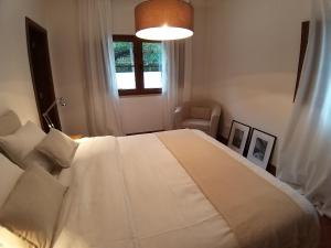 a bedroom with a large white bed and a window at Villa Abitureiras in Abitureiras