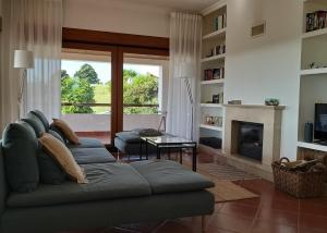 a living room with a couch and a fireplace at Villa Abitureiras in Abitureiras