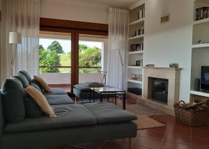 a living room with a couch and a fireplace at Villa Abitureiras in Abitureiras