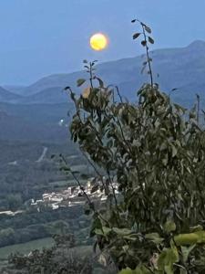 Une plante au sommet d'une montagne avec la lune dans l'établissement Apartamento rural El Pastor es un estudio con gran ventanal a Gredos, à Cabezas Bajas