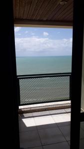 a view of the ocean from a window in a room at FLAT COSTA MAR in Recife