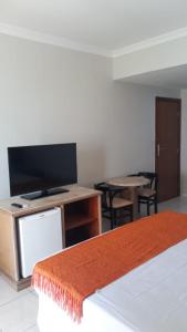 a room with a tv and a table with chairs at FLAT COSTA MAR in Recife