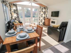 a living room with a dining room table and chairs at Pinecone Lodge - No 9 in Morpeth