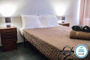 ein Hotelzimmer mit einem Bett und zwei Nachttischen in der Unterkunft Bernardo's Place in Ponta Delgada