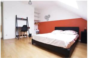 a bedroom with a bed with an orange wall at Cozy house for 8 people near LILLE in Tourcoing