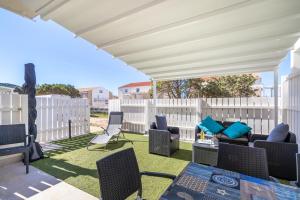 patio z krzesłami i białym płotem w obiekcie Stella Marina beach house w mieście Isola Rossa