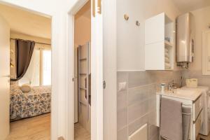 mała łazienka z umywalką i łóżkiem w obiekcie Stella Marina beach house w mieście Isola Rossa