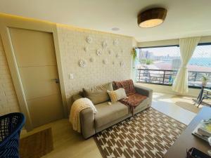 uma sala de estar com um sofá e uma janela em Flat Luxuoso Alto Padrao Frente Mar com 2 suites no Iate Plaza em Fortaleza