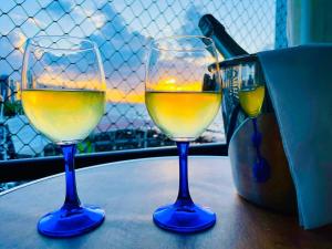two glasses of white wine sitting on a table at Flat Luxuoso Alto Padrao Frente Mar com 2 suites no Iate Plaza in Fortaleza