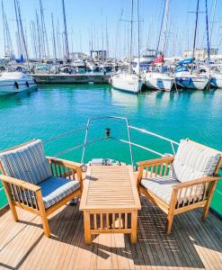 2 sillas y una mesa en un muelle con barcos en Salvador BAHIA Boat and Breakfast, en Lido di Ostia