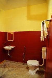 a bathroom with a toilet and a sink at Smith Guest House in Puducherry