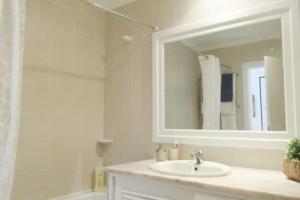 une salle de bains avec lavabo, miroir et baignoire dans l'établissement Cosy flat, Salgados Village, à Guia 22 autres photos