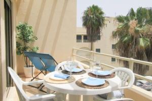 une table blanche et des chaises sur un balcon dans l'établissement Cosy flat, Salgados Village, à Guia