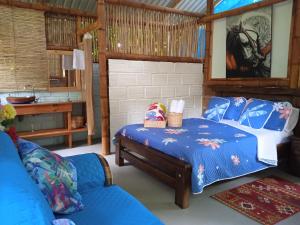 Finca Ecoturistica LOS JAGUEYES في Baraya: غرفة نوم بسرير واريكة