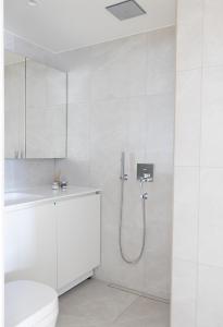 biała łazienka z prysznicem i toaletą w obiekcie 2ndhomes Beautiful & Modern Attic Studio in Kruununhaka w Helsinkach