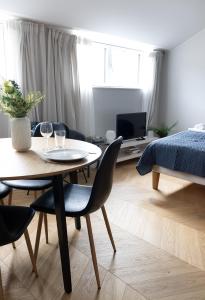 salon ze stołem, krzesłami i łóżkiem w obiekcie 2ndhomes Beautiful & Modern Attic Studio in Kruununhaka w Helsinkach