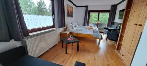 Schlafzimmer mit einem Bett, einem Schreibtisch und einem Fenster in der Unterkunft Quellenhof Altenau in Altenau