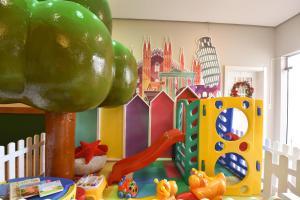 a childs play area with a playground and toys at Hotel Bertoluci in Gramado