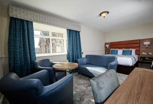 a hotel room with a bed and blue furniture at Bushtown Hotel & Spa in Coleraine