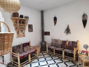 a room with rattan chairs and a fireplace at Vallparadis Pension Familiar" FIRDAUS" in Chefchaouen