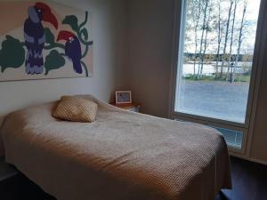 a bedroom with a bed and a large window at Villa by the river with beach sauna and jacuzzi in Rovaniemi