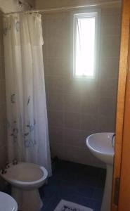 een badkamer met een wastafel, een toilet en een raam bij El Encuentro in Tanti
