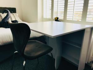 a white desk with a black chair in a room at Penthouse Suite, Central St Leonards, Sea View in St. Leonards