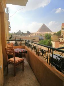 balkon ze stołem, krzesłem i piramidami w obiekcie Anubis kingdom Pyramids View w Kairze