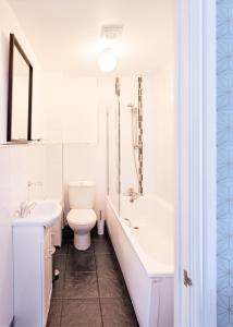 a bathroom with a toilet and a tub and a sink at No 5 Compass - Ilfracombe in Ilfracombe