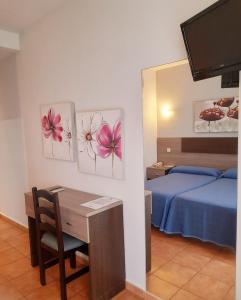 a room with a bed and a desk and a bed and a bedroom at Hostal La Colonia in Marbella